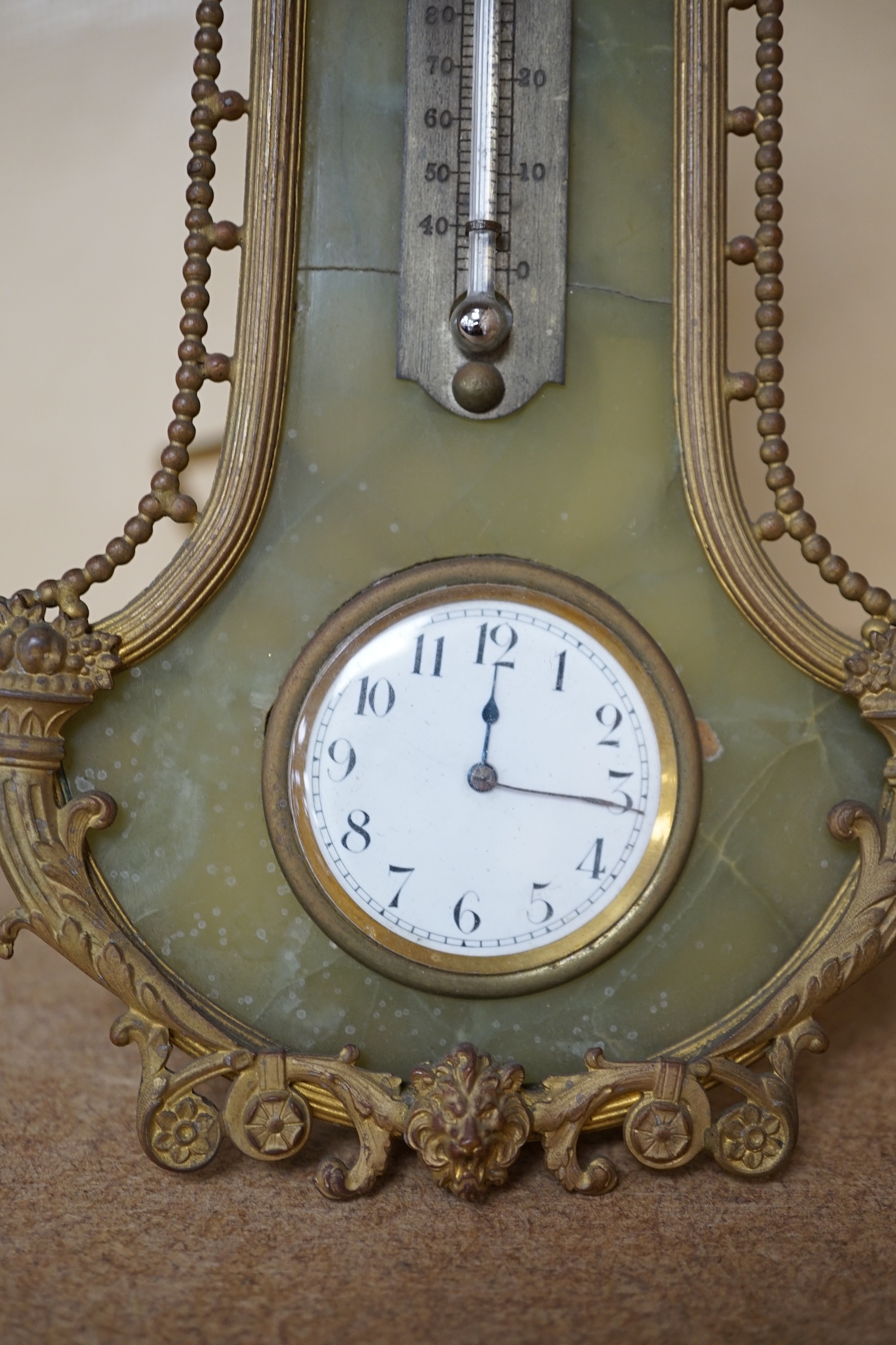 An onyx and gilt metal easel timepiece and thermometer, 20cm high. Condition - fair